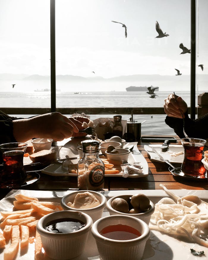 Relaxing breakfast by the sea with Turkish tea and various dishes. Ideal for travel and culinary concepts.